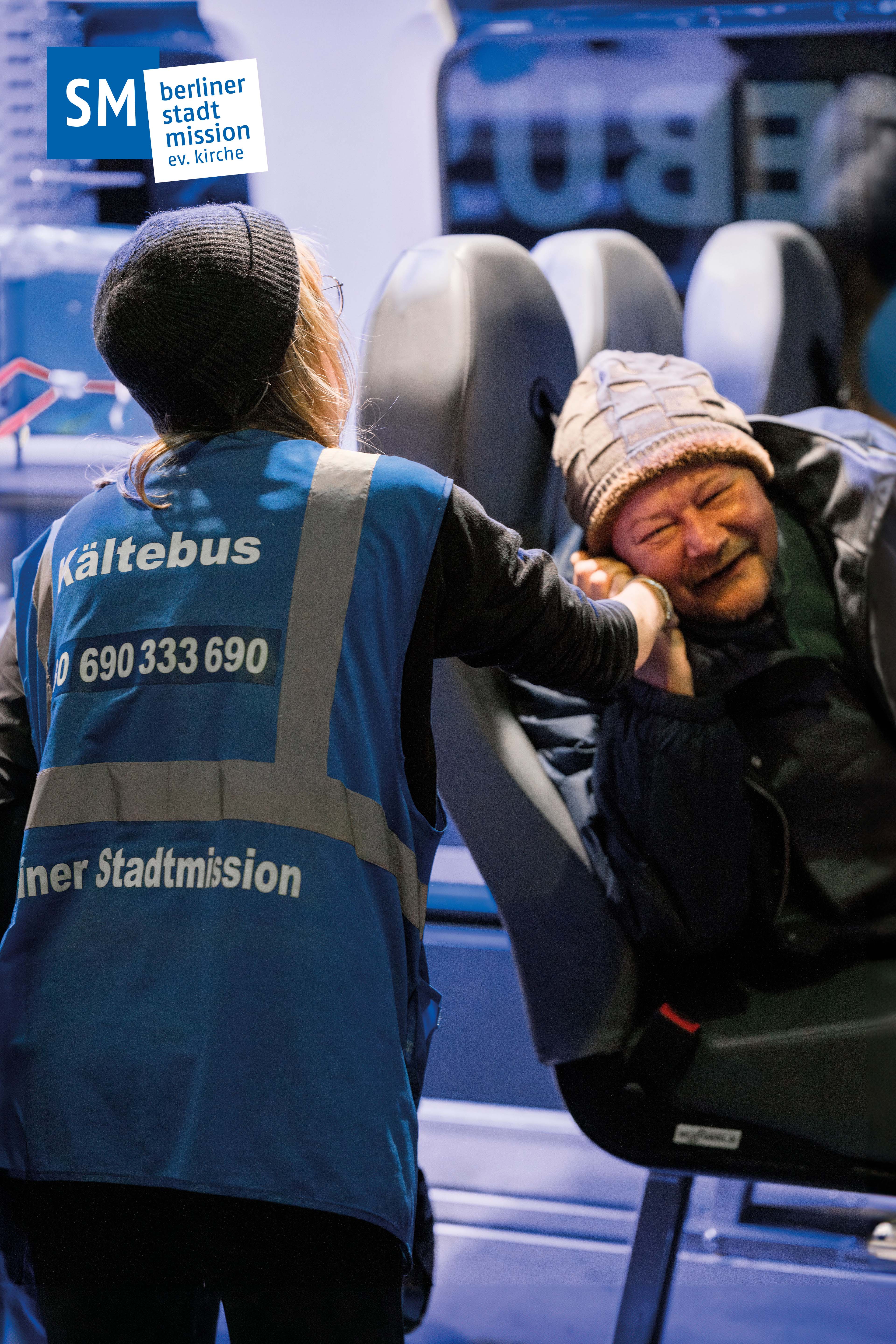 Mitarbeiterin des Kältebusses spricht mit einer Person.